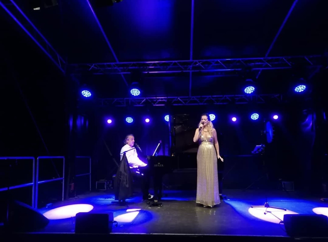 Hanna Czarnecka im goldenen Abendkleid singt bei der White Party, begleitet von José Rodriguez am Flügel